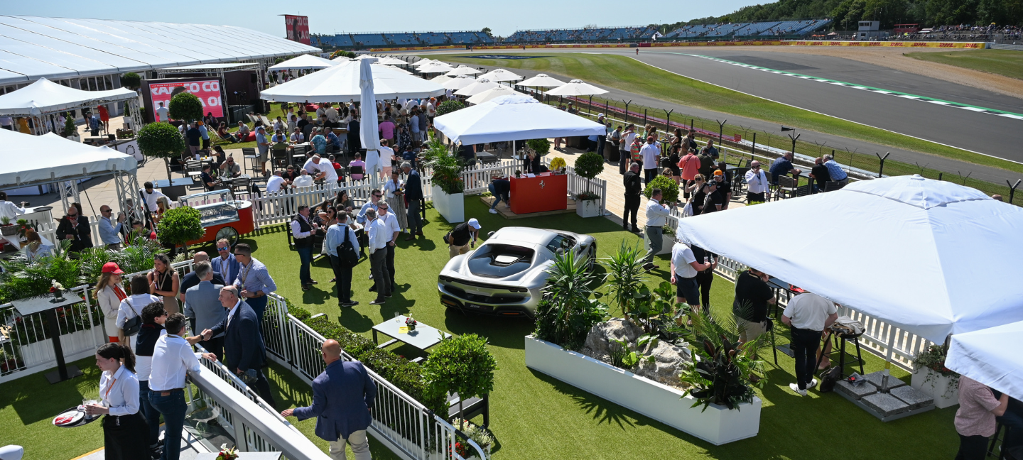 Shot of people at Casa Ferrari with a Ferarri car in the background