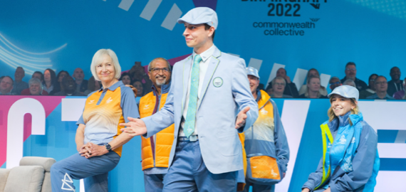 Five people on stage in the Birmingham 2022 Commonwealth Games uniforms
