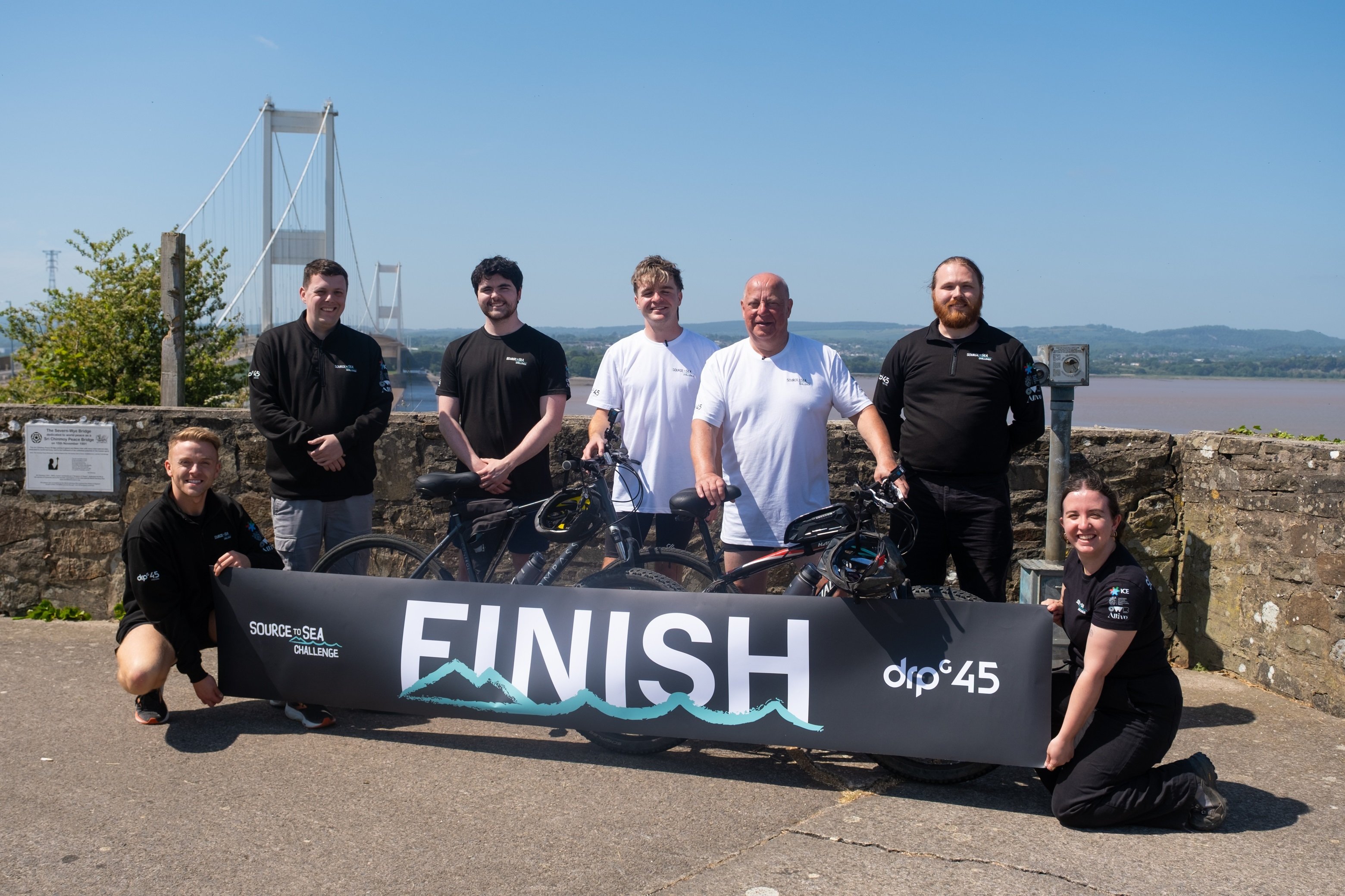 DRPG Source to Sea Challenge Crew cheering at Severn Bridge finish line.