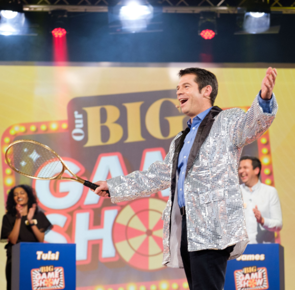 A man in a silver jacket holding a tennis racket as part of the Nationwide Our Big Night In Awards.