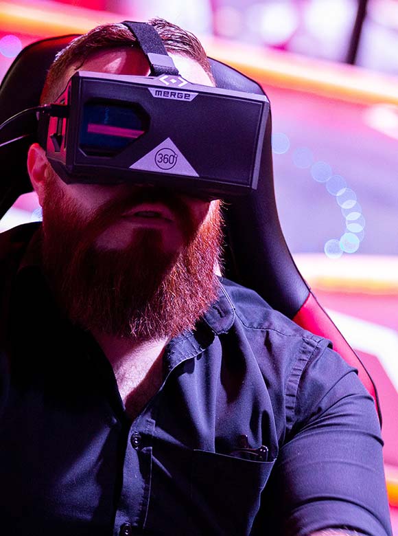 A man wearing a VR headset in a bright, colourful environment