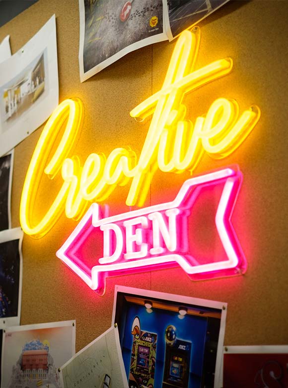 neon sign that says 'creative den'